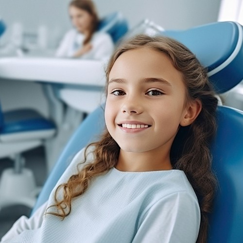 Young girl with curly hair smiling in dental chair