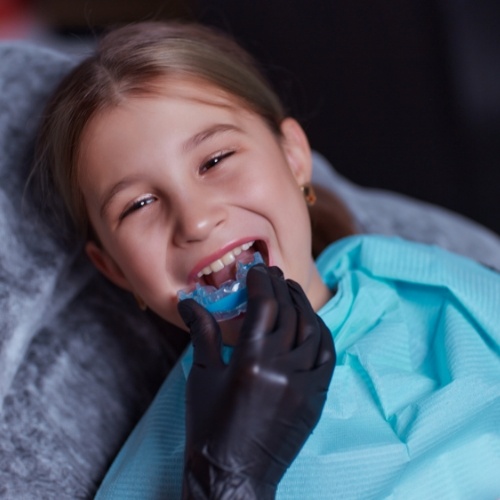 Young girl in dental chair receiving a mouthguard