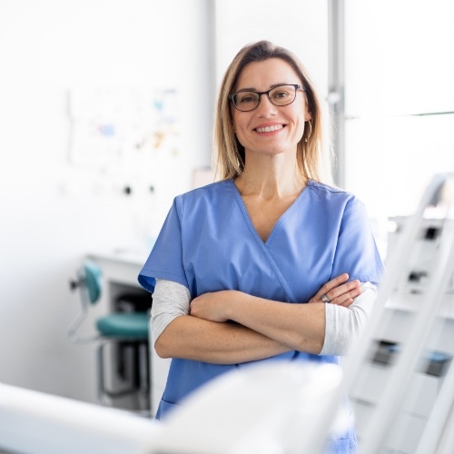 Dental team member smiling with arms crossed