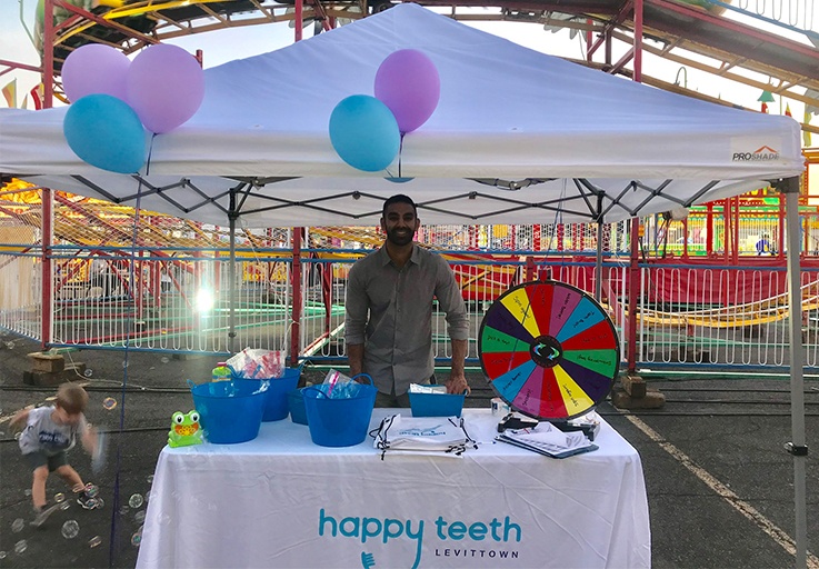 Doctor Singh behind information booth at a community event