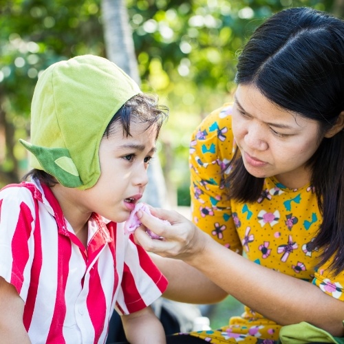 Mother holding cloth to her childs bleeding lip