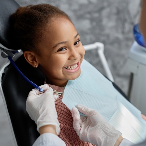 Child grinning right before receiving a tooth extraction