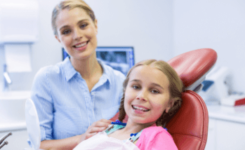 Little girl and mom smiling during dental checkup