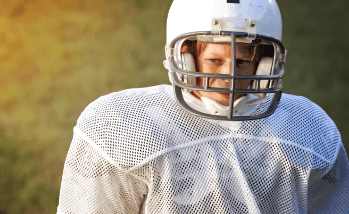 Young boy in football gear with athletic mouthguard