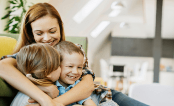 Smiling mother hugging her two children