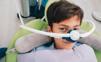 Young boy in dental chair with nitrous oxide sedation dentistry mask on his nose