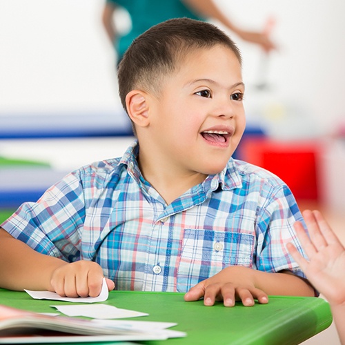 Young boy smiling and sitting at table