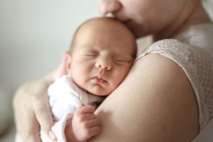 Woman holding newborn against her chest